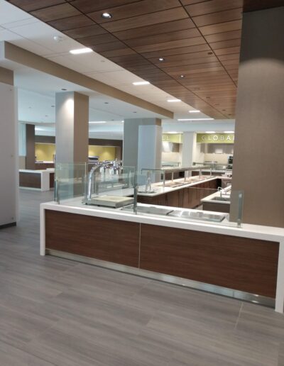 Modern cafeteria interior with serving counters and minimalist design.