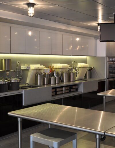 A modern commercial kitchen with stainless steel appliances and utensils.