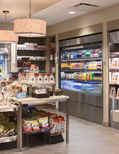 Modern convenience store interior with well-stocked shelves and refrigerated beverage cases.
